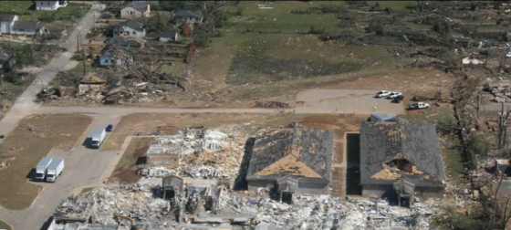 Close aerial view of the devastated school near University Blvd. The grass scouring within the streak of worst damage is consistent with a tornado of EF5 intensity, but the damage to the flattened school was deemed to be of high-end EF4 intensity due to the presence of undamaged light poles just south of the main building. (Image by Tim Marshall)