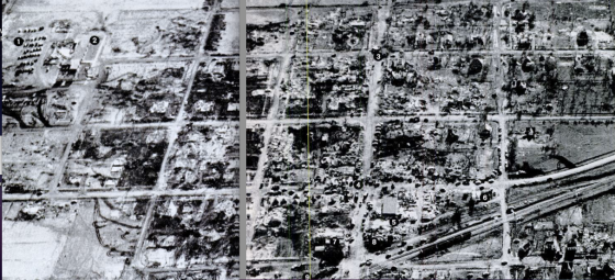 Composite aerial view of the town taken two days later after only moderate clean-up had occurred. The southern section of town (at left) was swept completely away, leaving a checkerboard of empty foundations. The rest of the community was left as a patchwork of F5 to F0 damage, with the least damage occurring in the northwest corner of town.